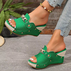 Green open-toe wedge sandals with chain buckle strap and stud accents.