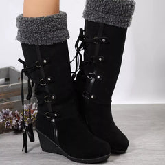 Black wedge boots with fuzzy top cuff and front buckles with lace-up detailing