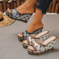 Peep toe wedge sandals with black-and-white patterned uppers and studded straps