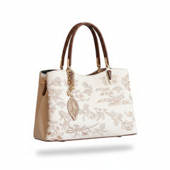 Ivory embroidered leather handbag with brown handles and gold hardware, side view
