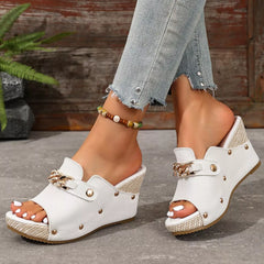 Open-toe white wedge sandals with gold chain buckle and studded strap, peep toe