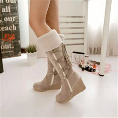 Light beige wedge boots with faux-shearling cuff and long lace-up strap detail