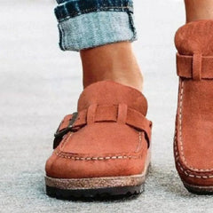 Suede round-toe low-heel loafer with buckle strap, stitched detail, visible sole