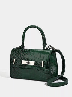 Green croc-embossed top-handle handbag with crossbody strap and front plaque
