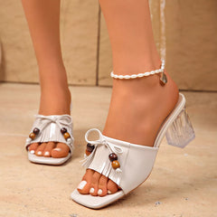 White open-toe block heel sandals with tassel fringe, beaded accents, clear heel