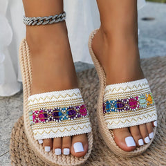 Open toe flat sandals with colorful jeweled embroidery on white woven straps and rope sole