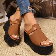 Open-toe wedge sandals with tan straps and black platform wedge heel