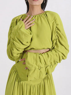 Green ruched long-sleeve crop top and high-waist skirt, ruffled cuffs and neckline