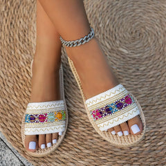 Open toe flat sandals with colorful jeweled stripe on white woven upper and rope sole