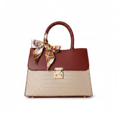 Crocodile-embossed top-handle handbag with burgundy top, beige body, gold clasp, scarf bow