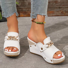Open-toe white wedge sandals with peep toe strap and gold chain buckle detail