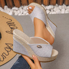 Peep-toe wedge sandals with light fabric straps and textured espadrille-style heel