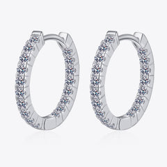 Sterling silver huggie hoop earrings with round moissanite stones around the oval