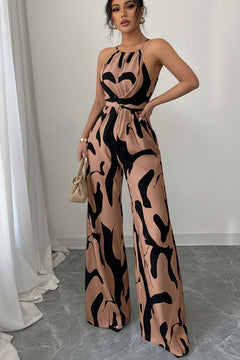 Sleeveless wide-leg jumpsuit with abstract tan-and-black print, halter neckline, wide legs