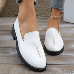 White loafers with round toe, V-cut vamp, and block heel with ridged sole