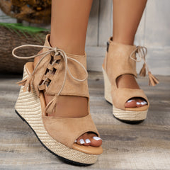 Light brown open-toe wedge sandal with lace-up ankle straps on woven wedge