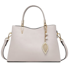 White leather top-handle handbag with pearl chain leaf charm and structured sides