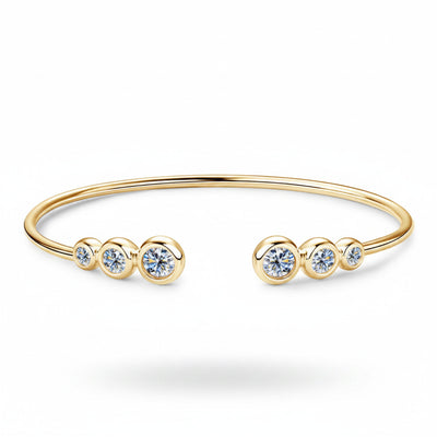 Gold-tone bracelet with five round clear stones and open cuff design