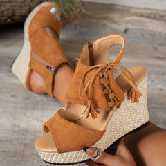 Brown open-toe wedge sandal with lace-up ankle and tassel fringe