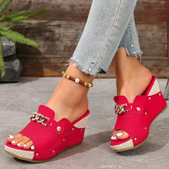 Rose red open-toe wedge sandals with chain buckle strap and metal studs.
