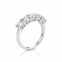 Silver eternity band ring with round prong-set moissanite stones, side view.