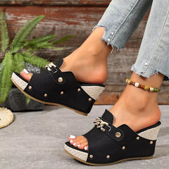 Black open-toe wedge sandals with chain-link strap and stud accents.