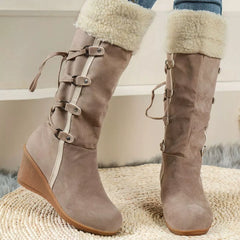 Beige round-toe wedge boots with faux-shearling cuff and buckle strap detailing