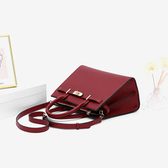 Burgundy leather handbag with detachable shoulder strap and front buckle clasp