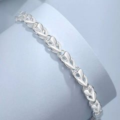 Silver heart link bracelet with polished engraved oval heart details