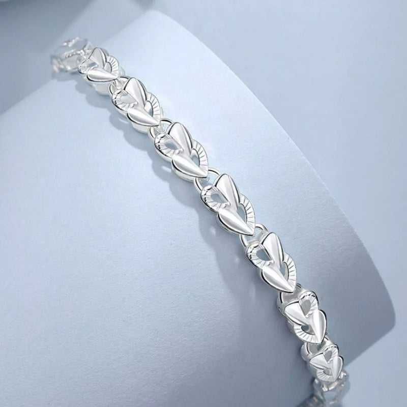 Silver heart link bracelet with polished engraved oval heart details