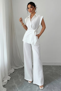 Off-white collared cap-sleeve peplum top with tied waist and wide-leg pants