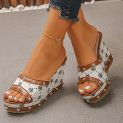 Peep toe wedge sandals with open toe, ankle strap, and studded black-and-white pattern