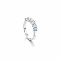 Silver moissanite ring with six small round stones in an angled halo band, side view.