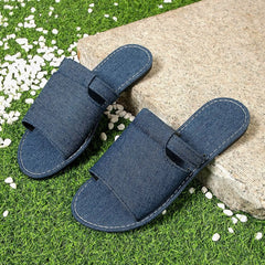 Pair of denim-blue open toe flat sandals with hook-and-loop top strap