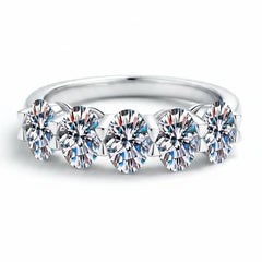 Silver band ring featuring a row of round prong-set moissanite stones across the top.