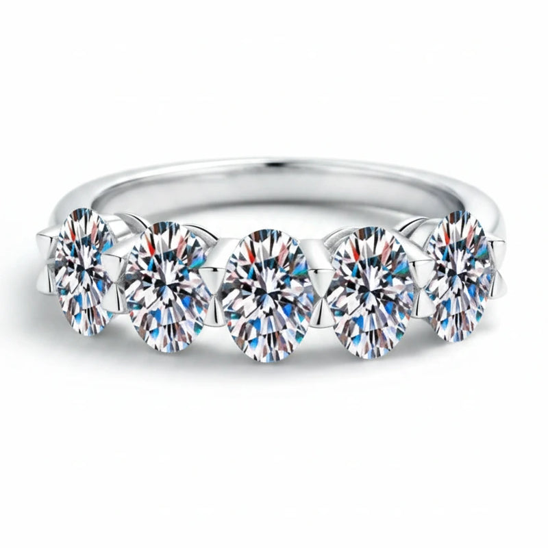 Silver band ring featuring a row of round prong-set moissanite stones across the top.