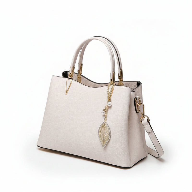 White leather top-handle handbag with dangling leaf charm and side strap