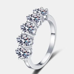 Silver moissanite eternity band ring with five round stone halos, prong-set.
