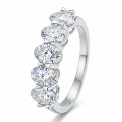 Silver ring with five round prong-set moissanite stones in shared halo setting.