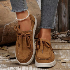 Brown lace-up loafers with round toe, white sole, and pearl ankle bracelet