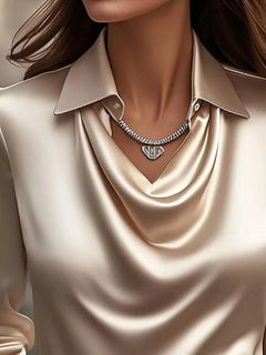 Tan satin cowl neck blouse with draped V neckline and short stacked chain necklace