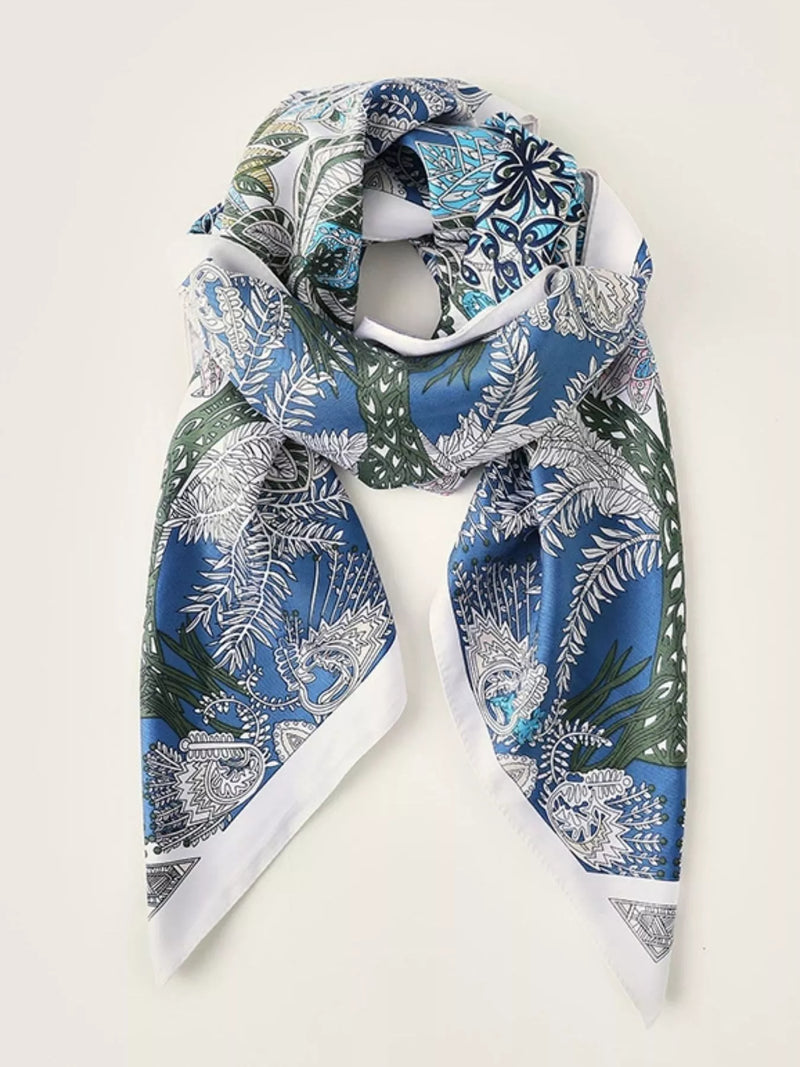 Blue silk scarf with white and green leaf and floral paisley print, draped