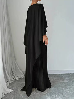 Black pleated maxi dress from back view with cape sleeves and draped hem