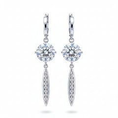 Silver moissanite drop earrings with round stones above oval pavé dangles in hoops