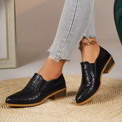 Point-toe block heel loafers in black with textured finish and gold chain ankle detail.