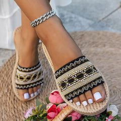 Open toe flat sandals with beaded black-and-gold woven straps and rope sole