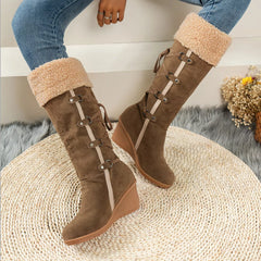 Brown round-toe wedge boots with faux-shearling cuff and side buckle-and-lace straps