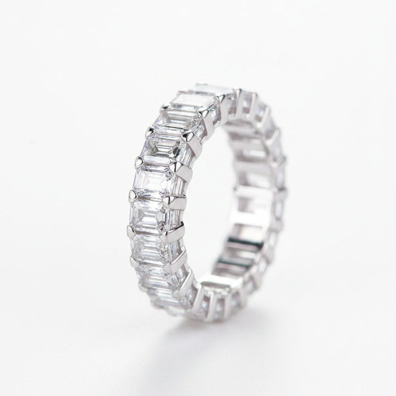 Rhodium-plated silver moissanite band ring with baguette-cut stones, side view.