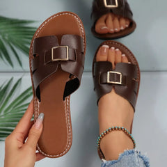 Coffee-brown open-toe slide sandals with square gold-tone buckle and stitched edges.