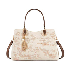 Ivory embroidered leather handbag with brown handles, gold drop charm, and side straps